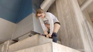 Youthful Woman In Glasses Pissing Through Clenched Legs